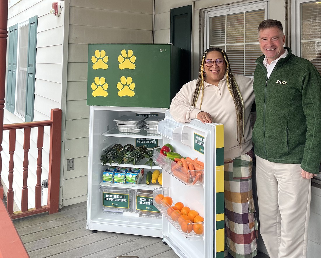 Jammella Anderson, Free Food Fridge Albany founder, and Siena president Chris Gibson stand in front of the latest Free Food Fridge opening on Siena's campus on the porch of the St. Thomas More House. (Emily Benson photo)