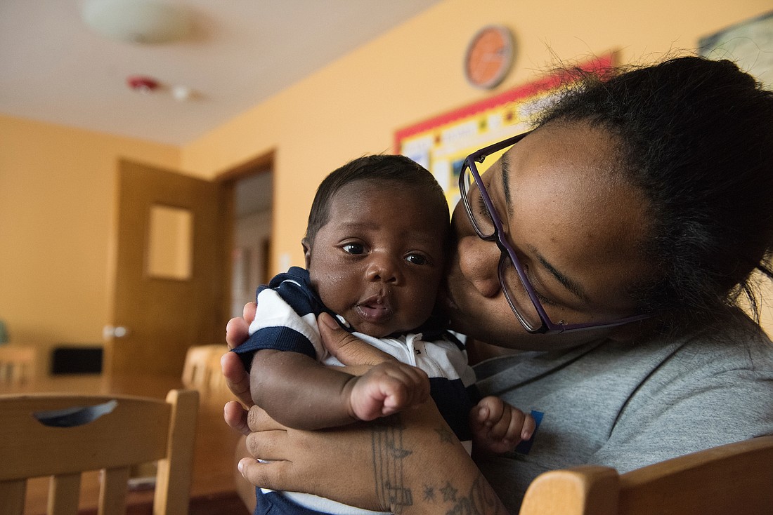A woman holds a baby in 2016 at a maternity home in Riverside, N.J., one of six pro-life maternity homes in the Good Counsel network. Good Counsel also has four in New York state and one in Alabama and works with other homes all over the country. The Riverside facility houses about a dozen expectant mothers, provides a safe environment for the women to continue their pregnancy, and offers continuing education, job training and material support. (OSV News/CNS file photo, Jeffrey Bruno) .