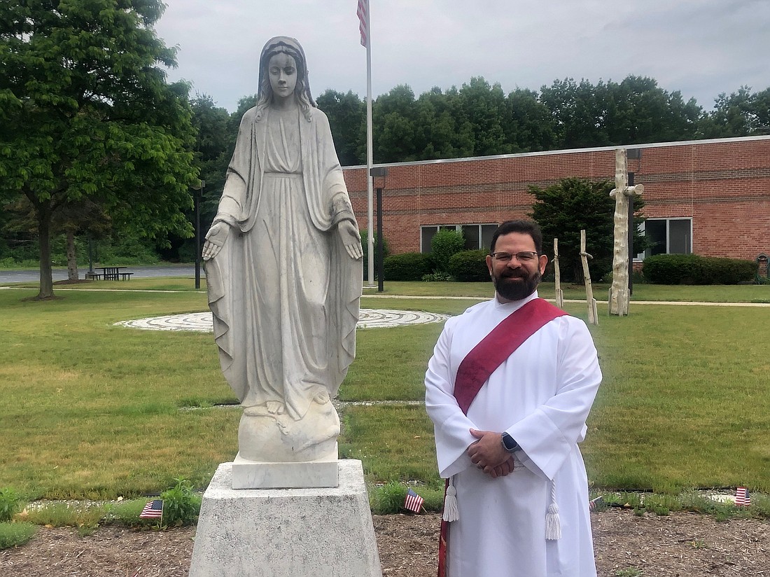 Deacon Eddie Trevino stands in front of a statue of the Blessed Mother outside of St. Edward the Confessor Church where he is the director of Faith Formation and Youth Ministry. At the end of the story, Trevino Deacon shows off one of his stoles that has embroidered the words of Psalm 8, one of his favorites: “Lord, our Lord, how majestic is your name in all the earth!” (Mike Matvey photos)