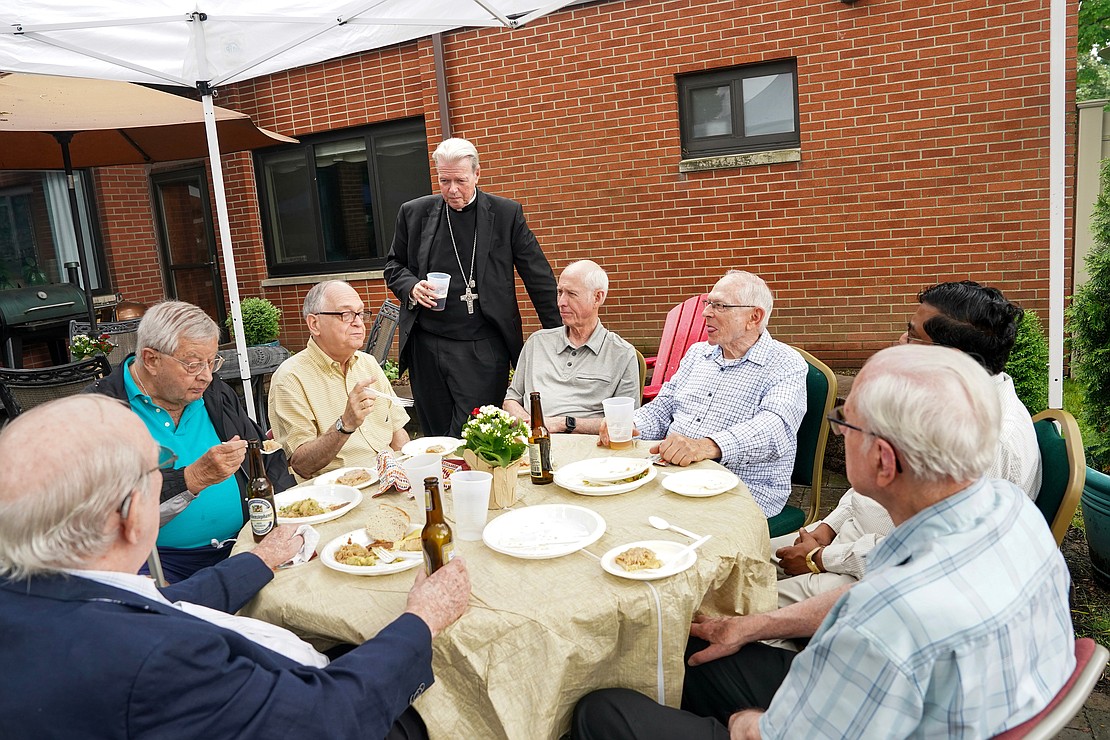 Bishop Edward B. Scharfenberger mingles with fellow priests during a gathering to celebrate his 50 years in the priesthood on Sunday, July 2 at his residence in Albany.  Cindy Schultz for The Evangelist