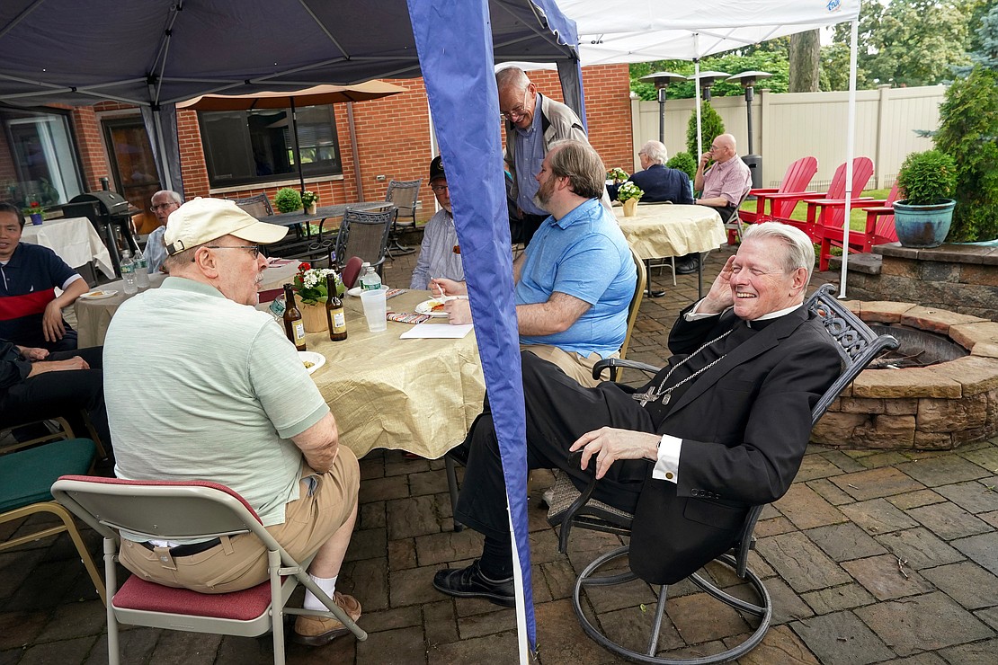 Bishop Edward B. Scharfenberger relaxes with fellow priests during a gathering to celebrate his 50 years in the priesthood on Sunday, July 2 at his residence in Albany.  Cindy Schultz for The Evangelist