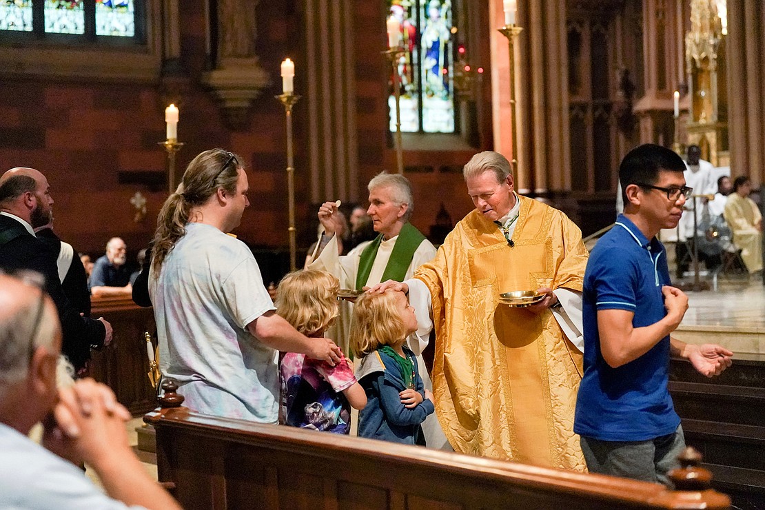Bishop Edward B. Scharfenberger places his hand on a child’s head at communion during a Mass to honor his 50 years in the priesthood on Sunday, July 2 at the Cathedral of Immaculate Conception in Albany.  Cindy Schultz for The Evangelist