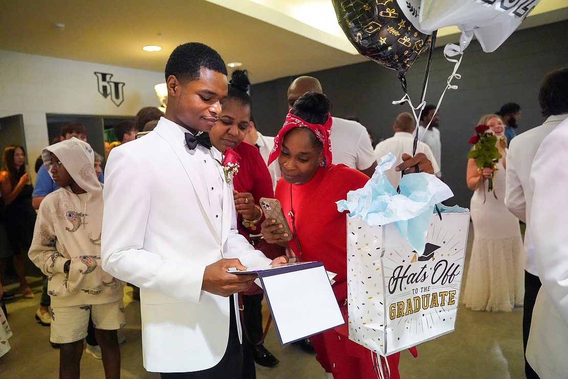 Graduate Tajon Osbourne Johnson, left, shows his diploma to family members following Central Catholic commencement exercises on Saturday, June 24, 2023, at Hudson Valley Community College in Troy, N.Y.  Cindy Schultz for The Evangelist