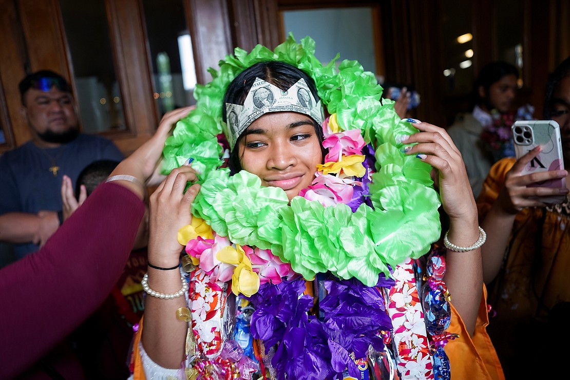 Graduate Kloreen Ifenuk receives garlands and a money crown from relatives as they wish her good fortune, as they do in the Micronesia tradition, following Notre Dame-Bishop Gibbons commencement exercises on Saturday, June 24, 2023, at St. John the Evangelist in Schenectady, N.Y.  Cindy Schultz for The Evangelist