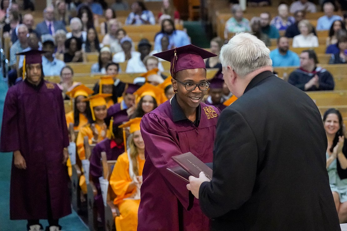 Graduate Donovan Smith, center, receives his diploma from Father Robert Longobuco during Notre Dame-Bishop Gibbons commencement exercises on Saturday, June 24, 2023, at St. John the Evangelist in Schenectady, N.Y.  Cindy Schultz for The Evangelist