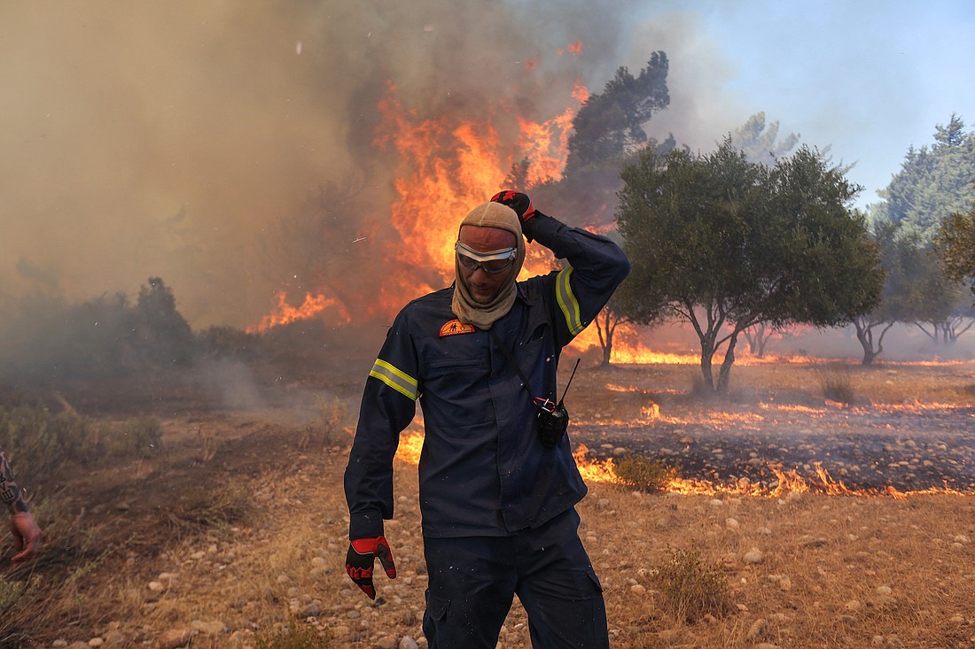 A firefighter walks next to rising flames as a wildfire burns near the village of Vati, on the island of Rhodes, Greece, July 25, 2023. Extreme heat waves have seen Greece, Italy and Spain record all-time high temperatures with the heat index in several Middle Eastern countries reaching 152 degrees Fahrenheit, near the limit of human survival. (OSV News photo, Nicolas Economou, Reuters)
