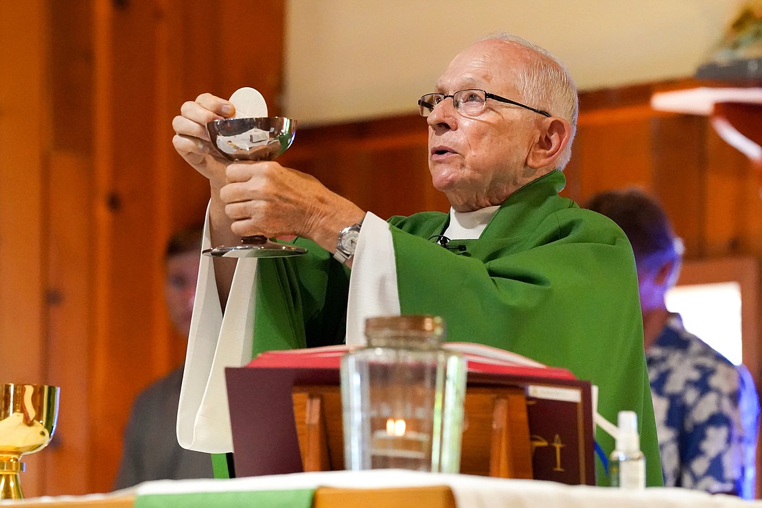 Father Robert Hohenstein holds up the body and blood of Christ during mass on Sunday, July 23, 2023, at St. Isaac Jogues Chapel, which is open from Memorial Day “til the snow flies,” in Saratoga Springs, N.Y.  Cindy Schultz for The Evangelist
