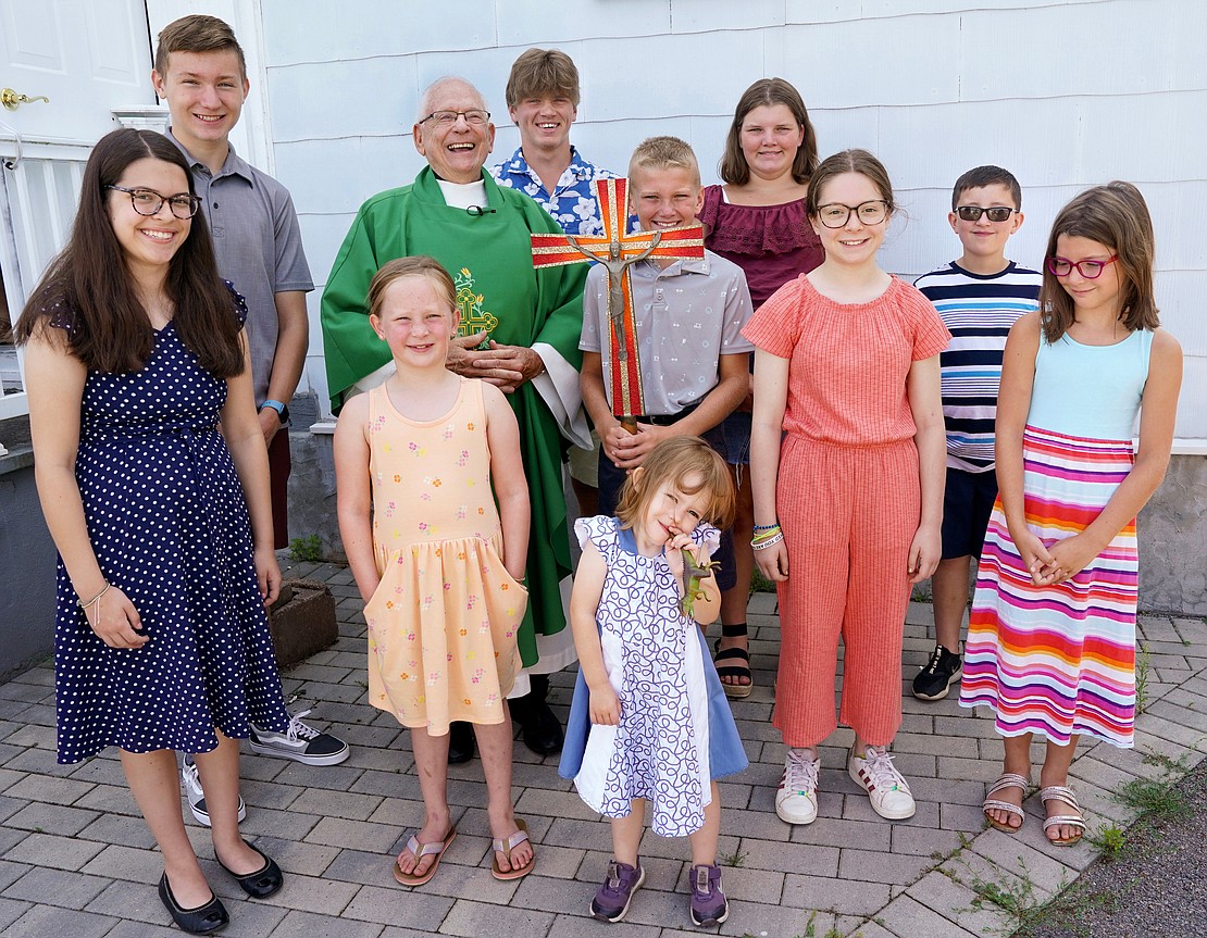 Father Robert Hohenstein poses with the children and young adults following mass on Sunday, July 23, 2023, at St. Isaac Jogues Chapel, which is open from Memorial Day “til the snow flies,” in Saratoga Springs, N.Y.  Cindy Schultz for The Evangelist