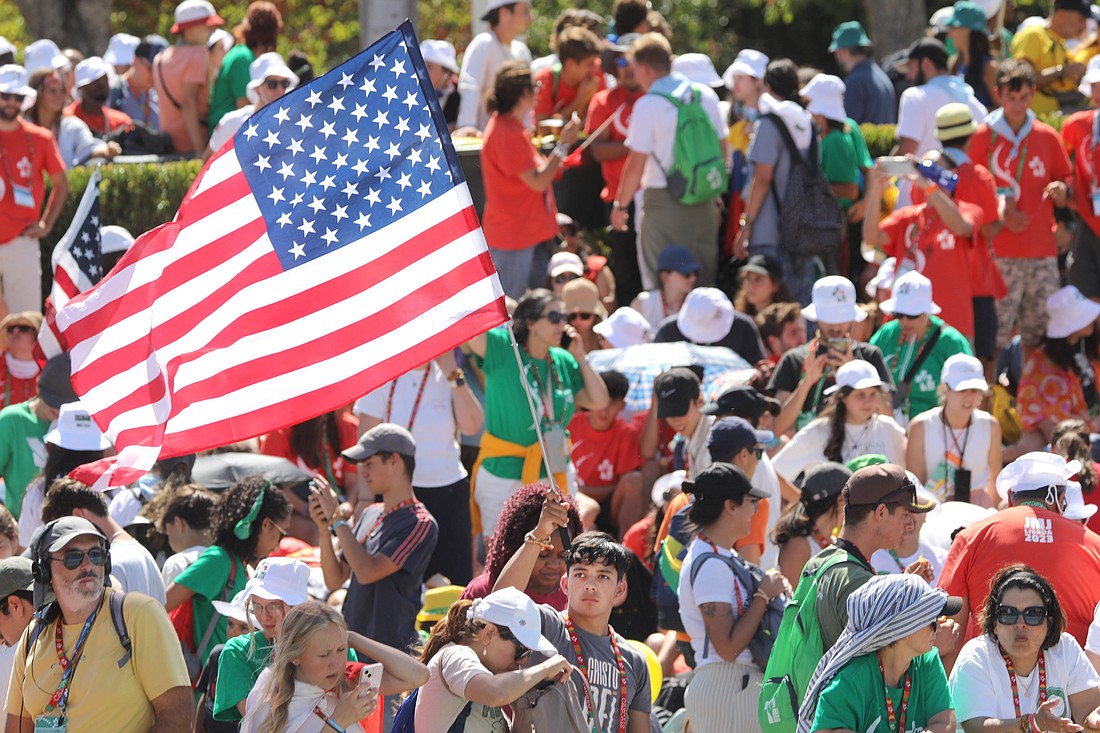 A U.S. pilgrim waves the American flag as he waits for the arrival of Pope Francis for the welcome ceremony for Pope Francis during World Youth Day at Eduardo VII Park in Lisbon, Portugal, Aug. 3, 2023. (OSV News photo/Bob Roller)