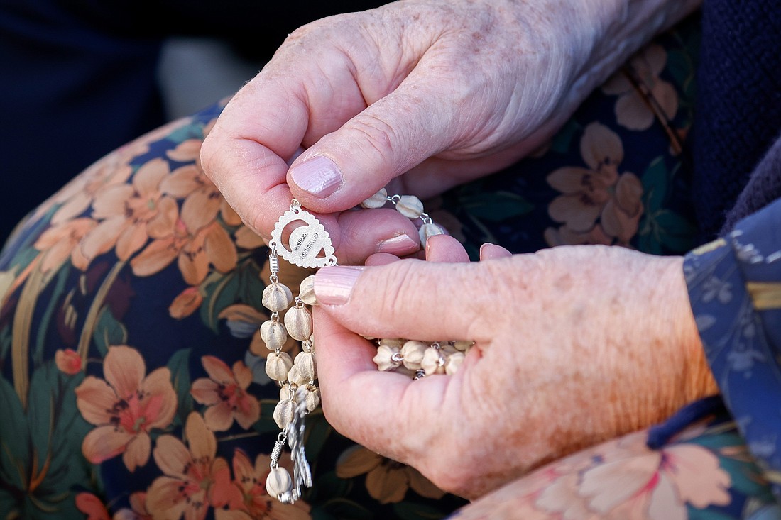 A woman holds a rosary during the Pope Francis’s Mass opening the assembly of the Synod of Bishops in St. Peter’s Square at the Vatican Oct. 4, 2023. (CNS photo/Lola Gomez)