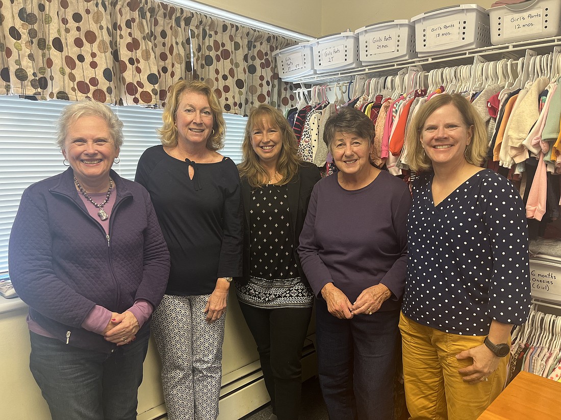 Birthright Center volunteers Ruth Bullett (from l.), Cindy Vitale, Lynee Daly and Michele Fernandez and Simone McGuinness, director of the center in Schenectady, stand in front of the baby clothes display at their Jay Street location. Birthright is a non-denominational, volunteer, pregnancy care center that helps clients navigate their pregnancies. (Emily Benson photos)