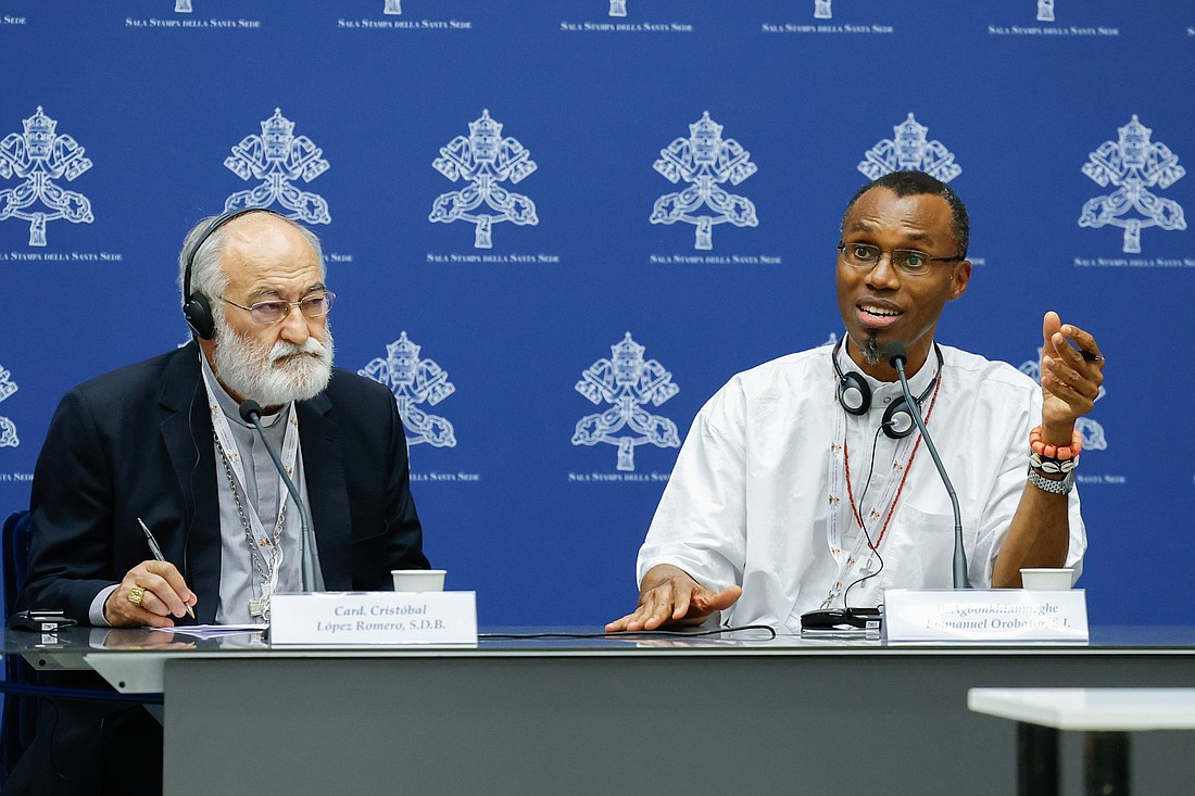 Jesuit Father Agbonkhianmeghe Orobator, dean of the Jesuit School of Theology at Santa Clara University in California, speaks during a briefing about the assembly of the Synod of Bishops as Cardinal Cristóbal López Romero of Rabat, Morocco, listen at the Vatican Oct. 17, 2023. (CNS photo/Lola Gomez)