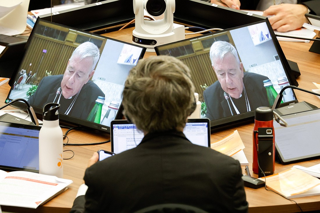 Cardinal Jean-Claude Hollerich, relator general of the synod, is seen on a video screen as he introduces the fourth section of the working document at a session of the assembly of the Synod of Bishops in the Vatican's Paul VI Audience Hall Oct. 18, 2023. (CNS photo/Lola Gomez)