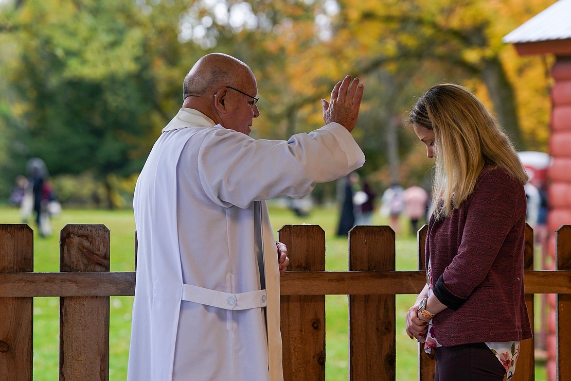 Monsignor Dennis Duprey of the Ogdensburg Diocese, left, absolves Krissie Bast of Peru, NY, of her sins during the Eucharistic Congress on Saturday, Oct. 21, 2023, at Our Lady of Martyrs Shrine in Auriesville, N.Y. “I feel lighter and can enjoy the beauty of being with so many Catholics,” Ms. Bast said after confession.  Cindy Schultz for The Evangelist