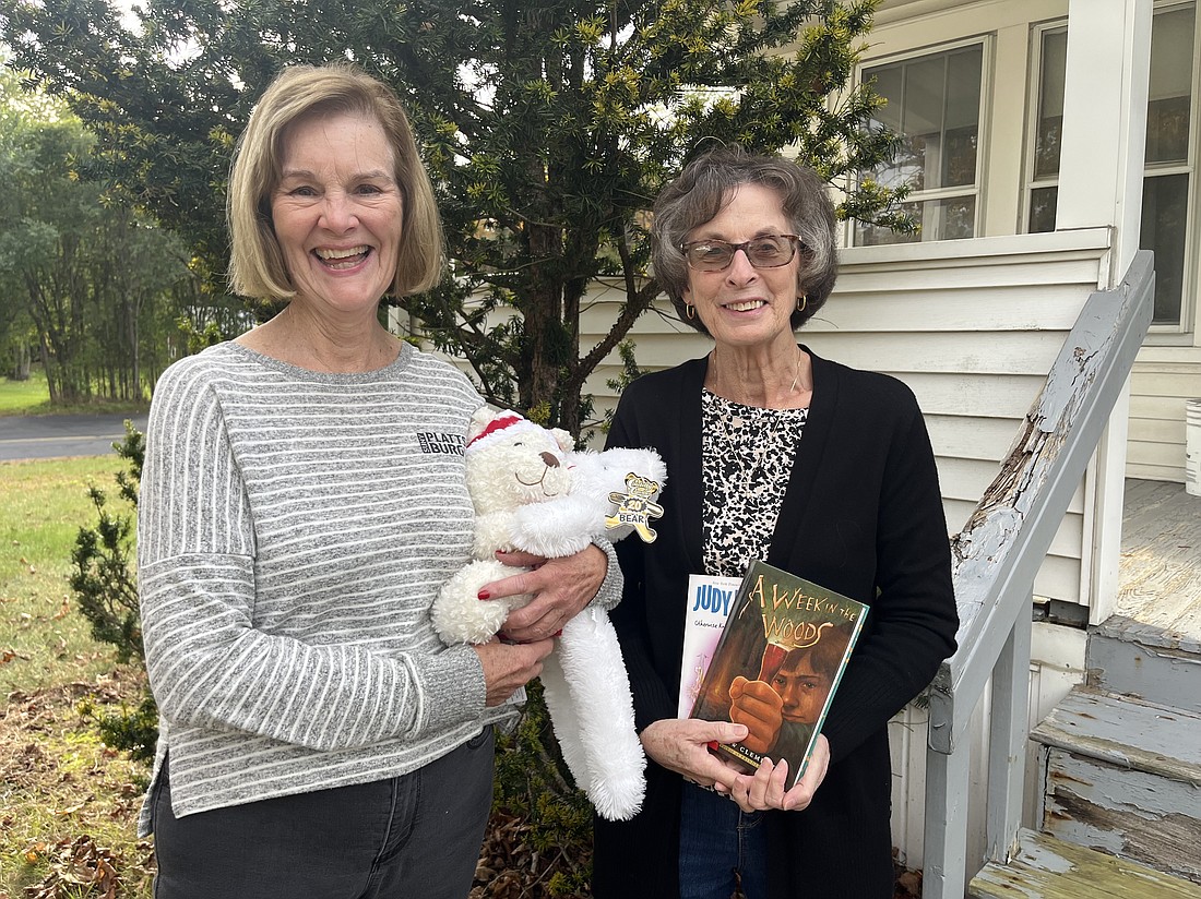 Jeanette May (at l.), previous president of the Christ Child Society Albany chapter and member of the National Christ Child Society Board of Directors, and Kathy Decatur, committee chair for the Albany chapter’s literacy program, stand in front of the chapter house. May holds teddy bears while Decatur displays children’s books, each of which the nonprofit helps distribute to children in need. (Emily Benson photo)