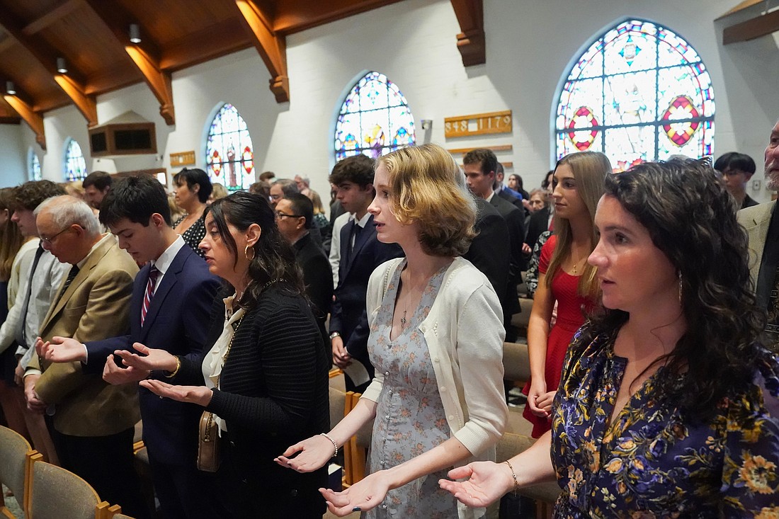 Candidate for confirmation join their sponsors in reciting "The Lord’s Prayer" during confirmation on Oct. 29 at St. Kateri Tekakwitha Parish in Schenectady. (Cindy Schultz photo for The Evangelist)