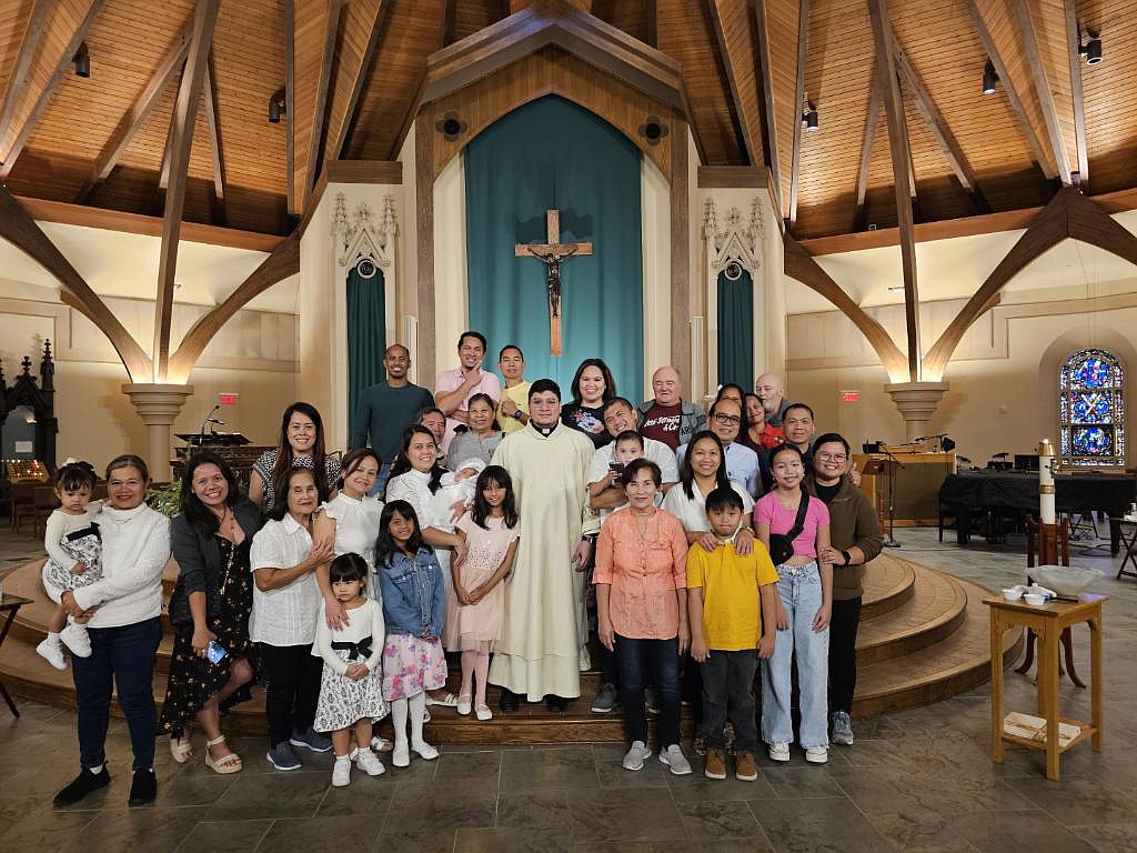 Deacon Daniel Vallejo (c.) is shown after a baptism at Christ the King. Vallejo will be ordained to the priesthood on Nov. 18 at the Cathedral. (Photo provided)