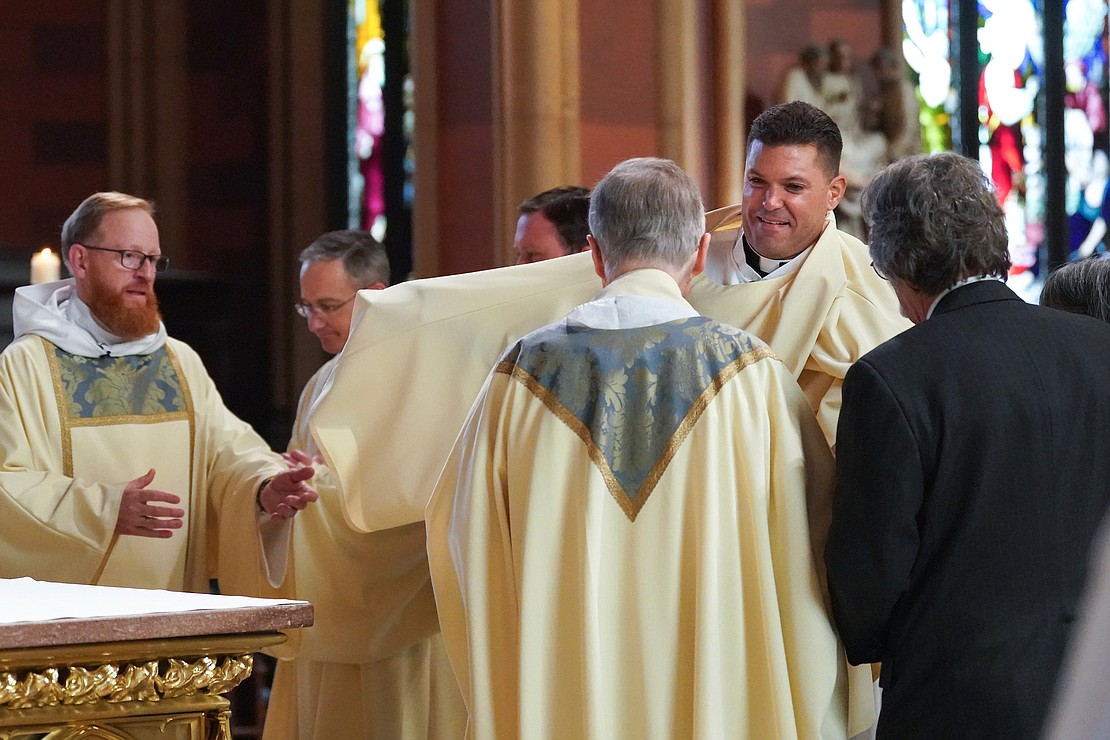 Paul McDonald, right, receives help donning his robe as he is vested with stole and dalmatic during their ordination for deacon on Saturday Nov. 18, 2023, at the Cathedral of Immaculate Conception in Albany, N.Y.  Cindy Schultz for The Evangelist