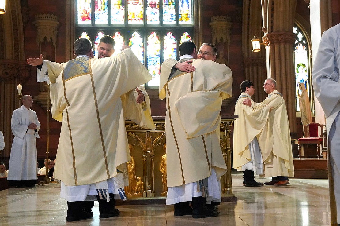 Deacons Paul McDonald (l.) and Tom Fallati (c.) and Father Daniel Vallejo are welcomed into the fraternity of deacons and priests during their combined Ordination Mass ordination on Nov. 18 at the Cathedral of the Immaculate Conception in Albany. (Cindy Schultz photo for The Evangelist)