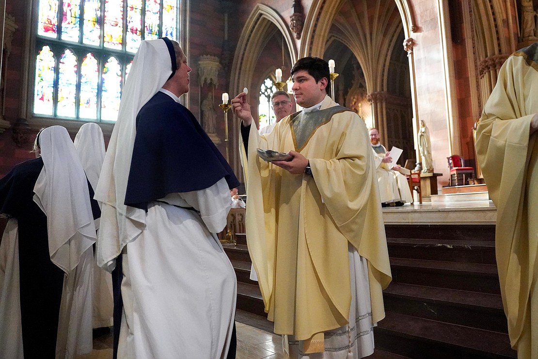 -Father Daniel Vallejo distributes Communion during his Ordination to the Priesthood on Nov. 18 at the Cathedral of the Immaculate Conception in Albany. (Cindy Schultz photo for The Evangelist)