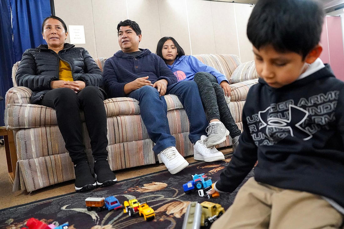 Noemi (from l.)  her husband, Enrique, and their children Michelle, 13, and Aron, 6, relax in the shared living space at St. Gabriel the Archangel Church in Schenectady. The church participates in the Family Promise of the Capital Region program and is one of several congregations in the area that hosts migrant families for a week at a time. (Cindy Schultz photo for The Evangelist)