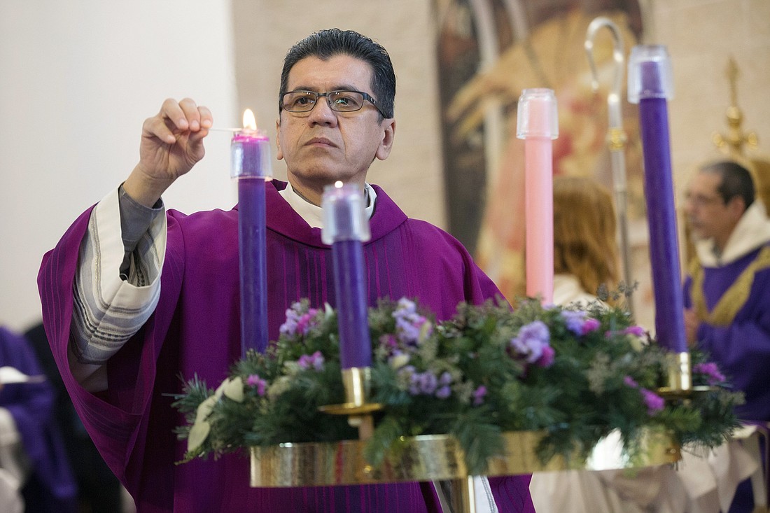 A deacon lights candles on the Advent wreath. The second Sunday of Advent falls on Dec. 10 this year. (CNS photo/Jaclyn Lippelmann, Catholic Standard)