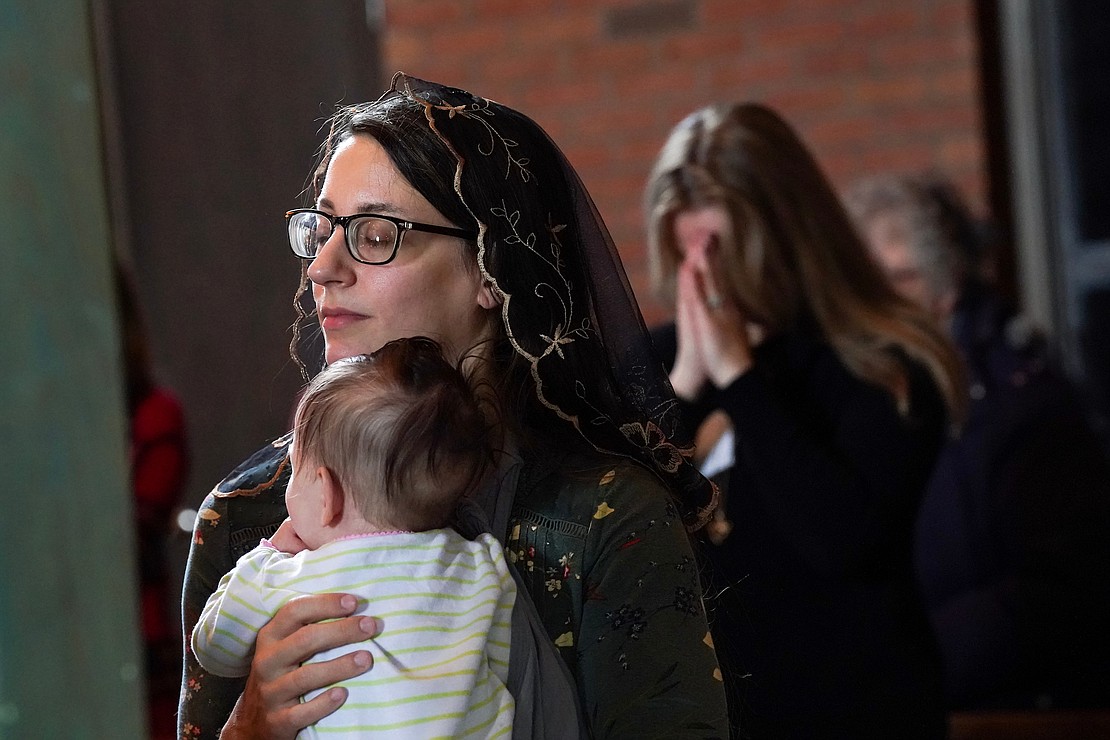 Bernadette Abeel of Schenectady holds her 4-month-old daughter, Marie, during Mass at the Unleashing Love Women’s Conference on Dec. 9 at St. Pius X Church in Loudonville. (Cindy Schultz photo for The Evangelist)