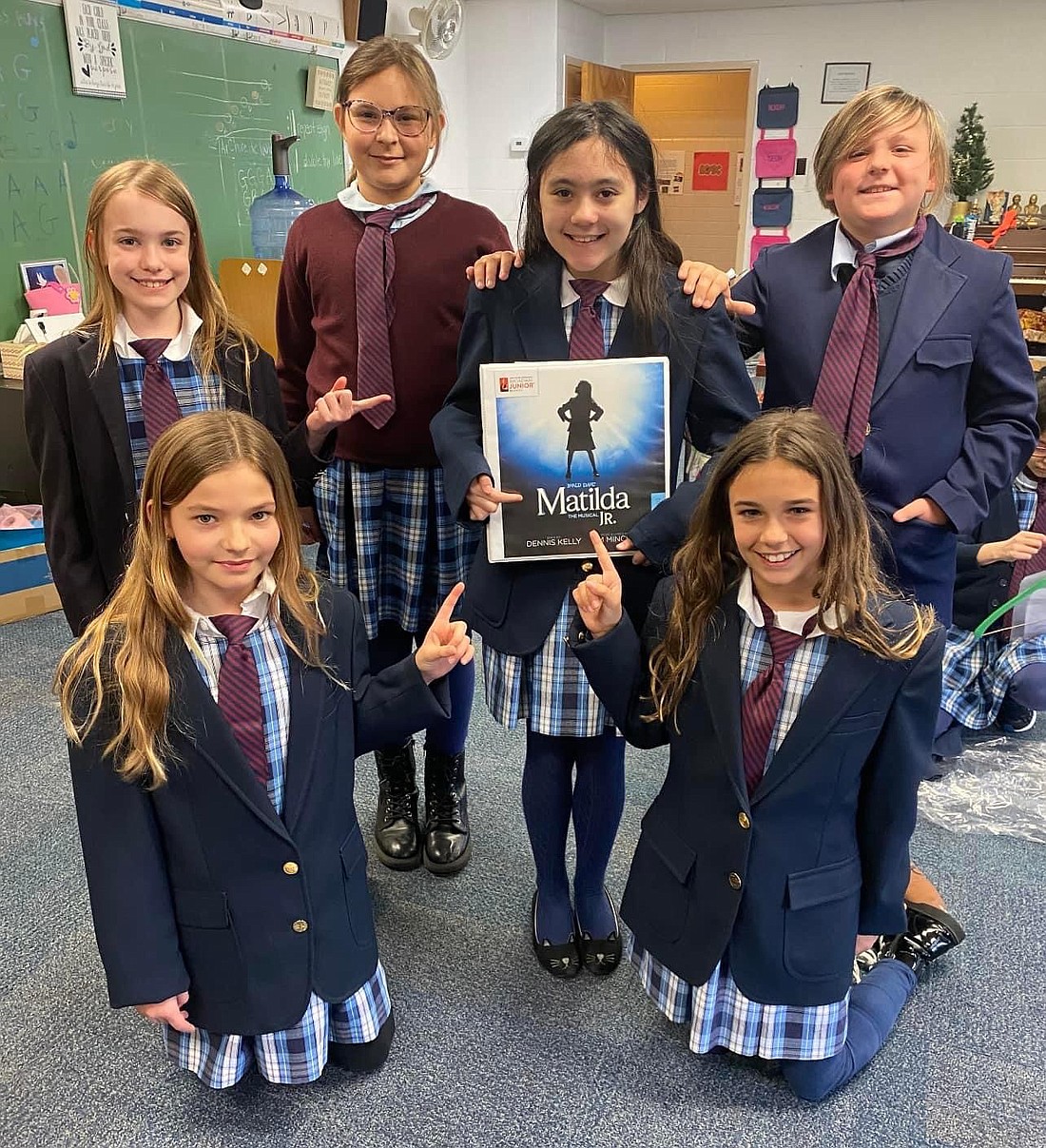 ST. MARY’S INSTITUTE choir members who performed in “Matilda Jr.” at SMI last May, proudly hold up a poster from their time in the drama club’s play. (Photo provided)