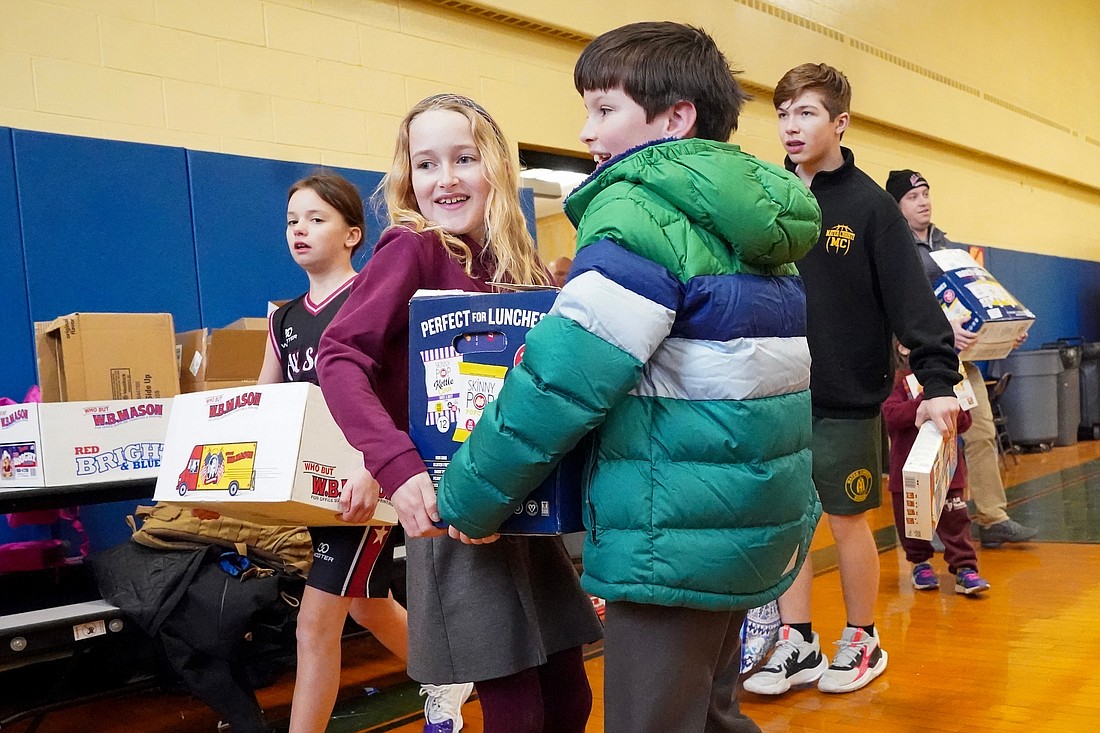 All Saints Catholic Academy students Addison Sebeck-Koss, center, and Ryan O’Connor carry a box of food donations during the drop off for the Blessed Sacrament food panty on Friday, Feb. 2, 2024, at Blessed Sacrament School in Albany, N.Y.  Cindy Schultz for The Evangelist