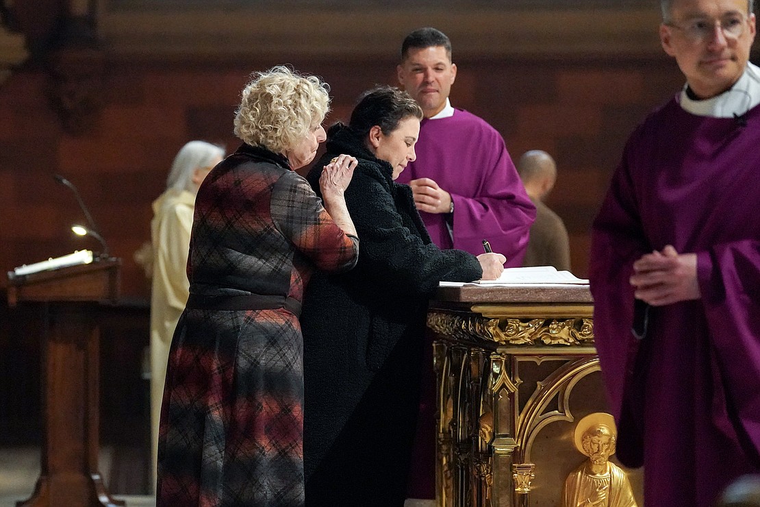 Sponsors join catechumens as they register their names in the Book of the Elect during the Rite of Election on Feb. 18 at the Cathedral of the Immaculate Conception in Albany. (Cindy Schultz photo for The Evangelist)