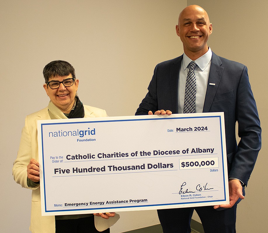 Sister Betsy Van Deusen, CEO of Catholic Charities of the Diocese of Albany, and Brian Sano, Regional Director of Community & Customer Management for National Grid, hold the historic $500,000 grant check that will help those in the Diocese of Albany pay their energy bills.