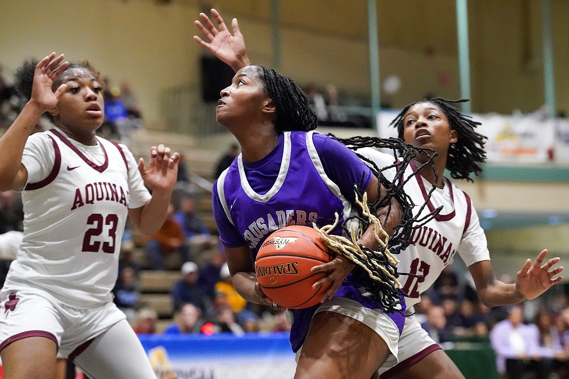 Catholic Central’s Akarra Gaddy, center, eyes the hoop as Aquinas Institute’s Jade Harvey, left, and Ajaya Orr defend during in their Class A semifinal basketball game on Friday, March 15, 2024, at Hudson Valley Community College in Troy, N.Y. CCS wins 63-46.  Cindy Schultz for The Evangelist