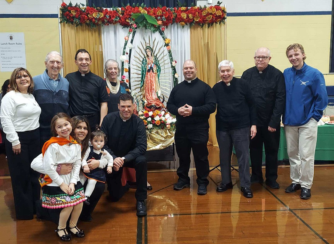 Deacon Paul McDonald (kneeling,) is shown at a celebration of the Feast of Our Lady of Guadalupe at St. Clement’s School in Saratoga Springs. (Photo courtesy of Deacon McDonald)
