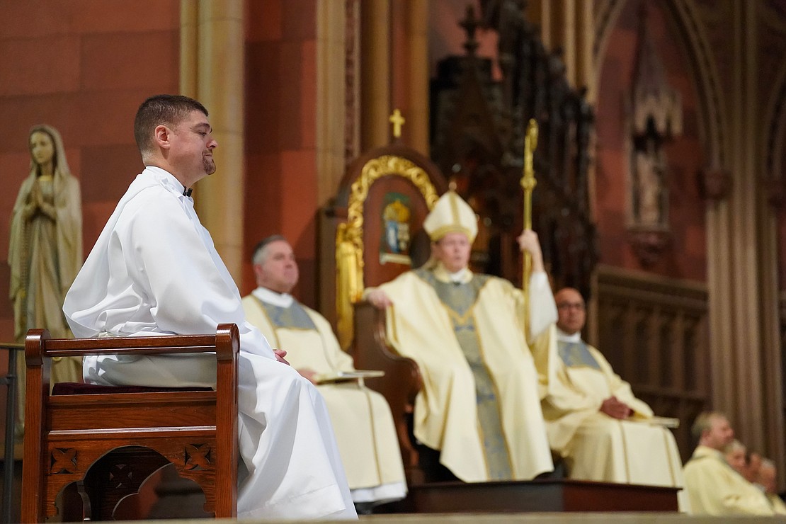 Candidate for deaconship Eric Ramirez, left, listens to Bishop Edward B. Scharfenberger’s homily during his Ordination of Deacons and an ordination of five candidates to the priesthood on Saturday, May 18, 2024, at The Cathedral of the Immaculate Conception in Albany, N.Y.  Cindy Schultz for The Evangelist