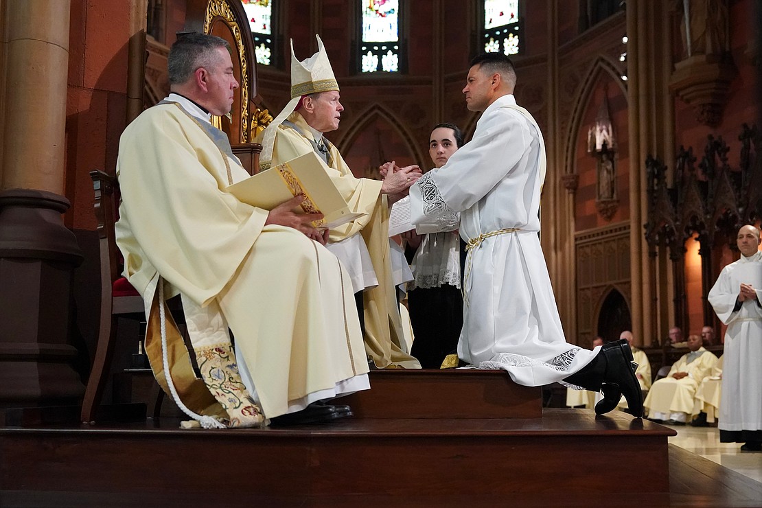 Paul McDonald, one of the candidates for the Ordination of Priests, right, gives the promise of obedience to Bishop Edward B. Scharfenberger on Saturday, May 18, 2024, at The Cathedral of the Immaculate Conception in Albany, N.Y.  Cindy Schultz for The Evangelist