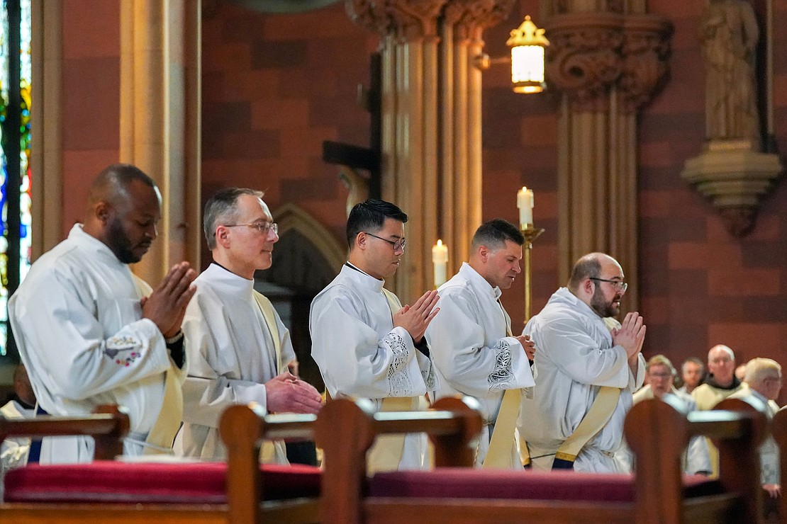 Candidates to the priesthood kneel for the laying of hands during the Ordination of Priests on Saturday May 20, 2023, at the Cathedral of Immaculate Conception in Albany, N.Y. From left are Anthony Chibueze Onu, Thomas Fallati, Joseph Tuan Van Pham, Paul McDonald and Adam Feisthamel.  Cindy Schultz for The Evangelist