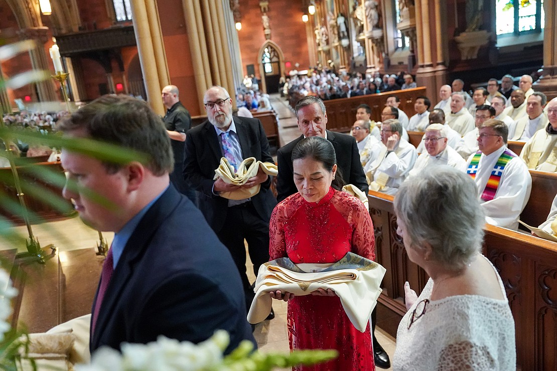 Family members carry vestments to robe candidates for priest during the Ordination of Priests on Saturday, May 18, 2024, at The Cathedral of the Immaculate Conception in Albany, N.Y.  Cindy Schultz for The Evangelist