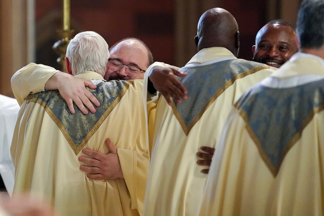 Newly ordained priests Adam Feisthamel, left, and Anthony Chibueze Onu, right, are welcomed into the priesthood during the Ordination of Priests on Saturday, May 18, 2024, at The Cathedral of the Immaculate Conception in Albany, N.Y.  Cindy Schultz for The Evangelist