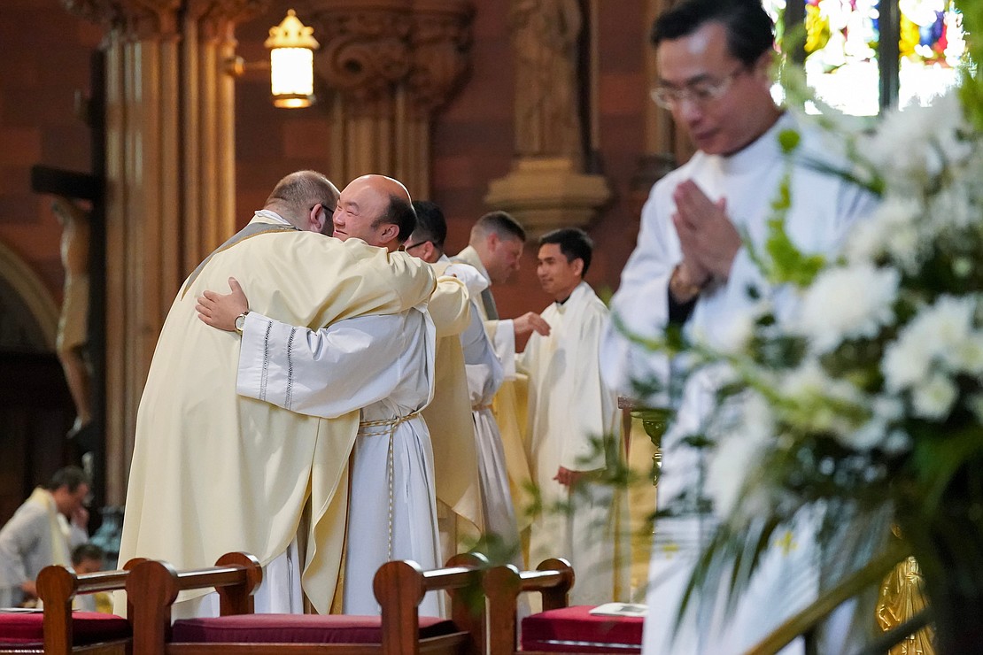 Father Quy Vo, center, welcomes newly ordained priest Adam Feisthamel, left, into the priesthood during the Ordination of Priests on Saturday, May 18, 2024, at The Cathedral of the Immaculate Conception in Albany, N.Y.  Cindy Schultz for The Evangelist