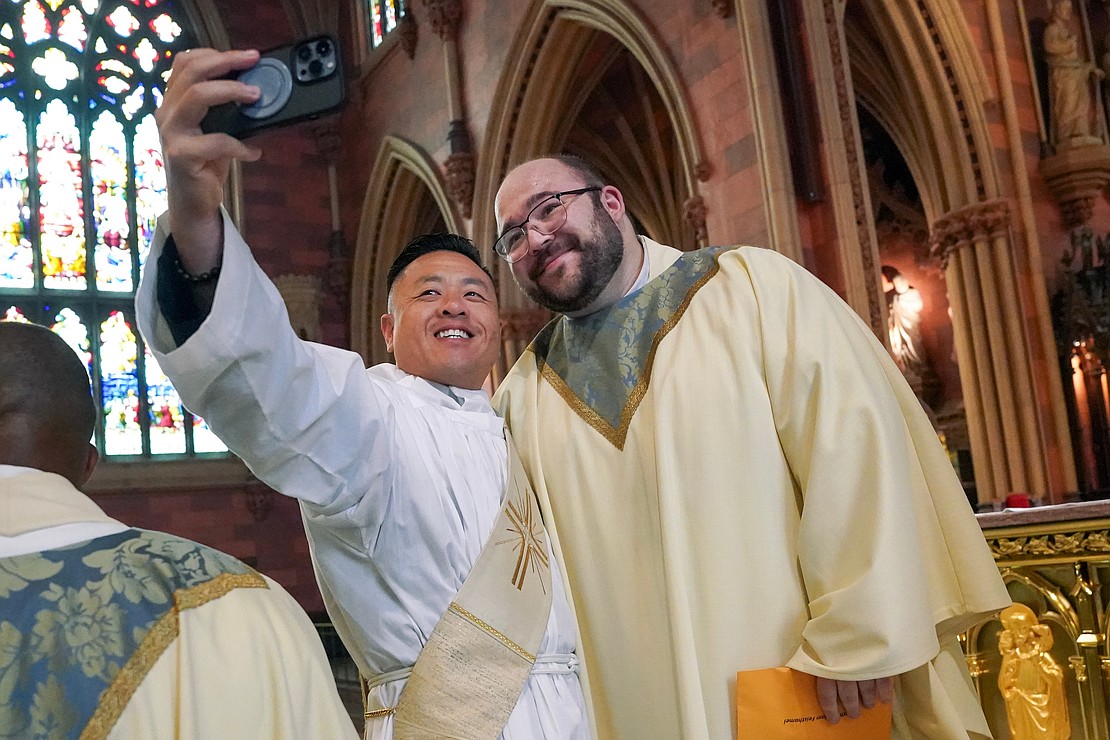 Newly ordained priest Adam Feisthamel, right, poses for a selfie with (tracking down name) following the combined Ordination of Priests and Deacons on Saturday May 18, 2022, at the Cathedral of Immaculate Conception in Albany, N.Y.  Cindy Schultz for The Evangelist