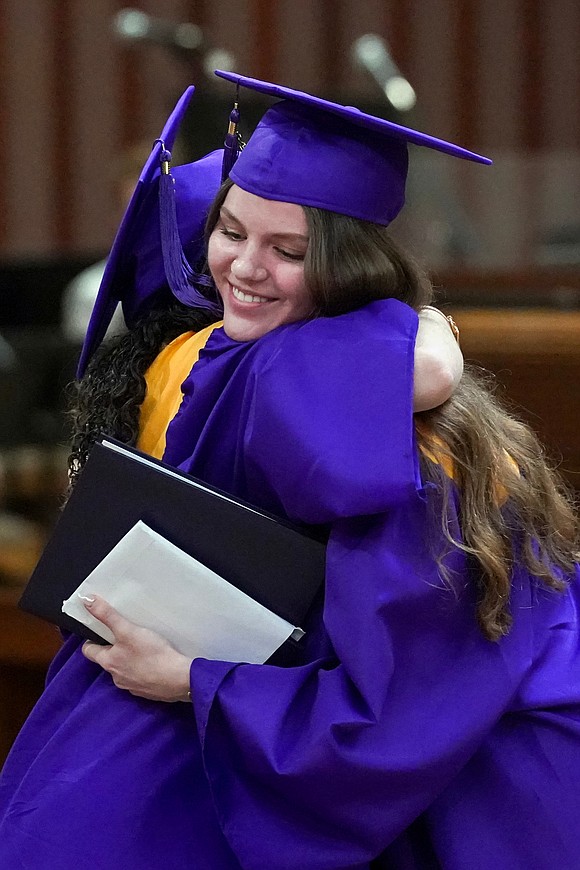 Valedictorian Caroline Bielefeld, right, embraces salutatorian Maeve Loftus-Graney during commencement exercises for Saratoga Central Catholic School on Friday, June 7, at Corpus Christi Church in Round Lake. (Cindy Schultz photo for The Evangelist)