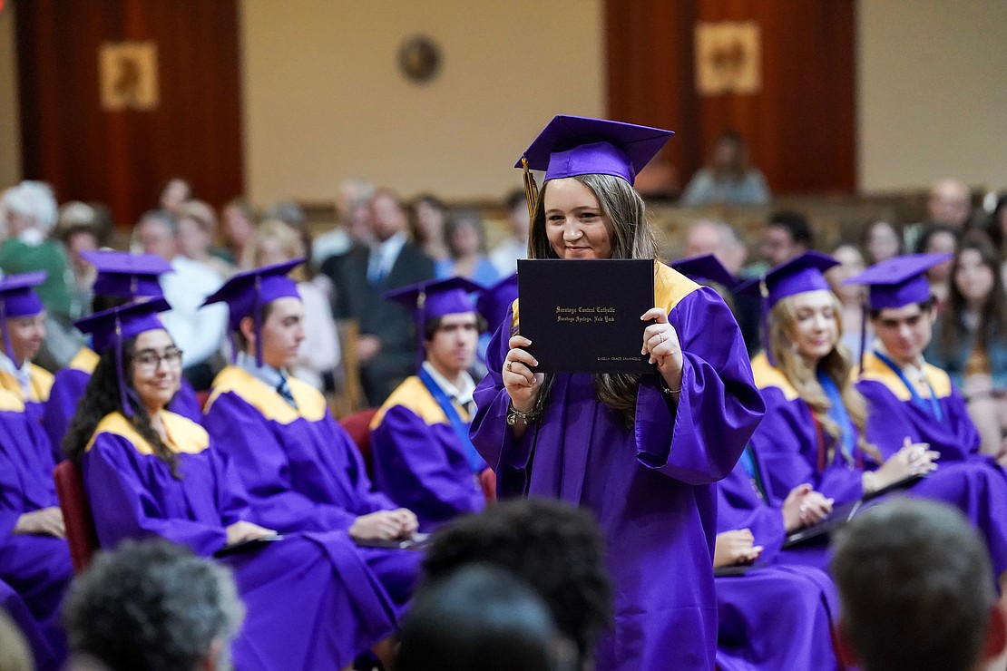 Isabella SanAngelo shows off her diploma for a picture during commencement exercises for Saratoga Central Catholic School on Friday, June 7, at Corpus Christi Church in Round Lake. (Cindy Schultz photo for The Evangelist)