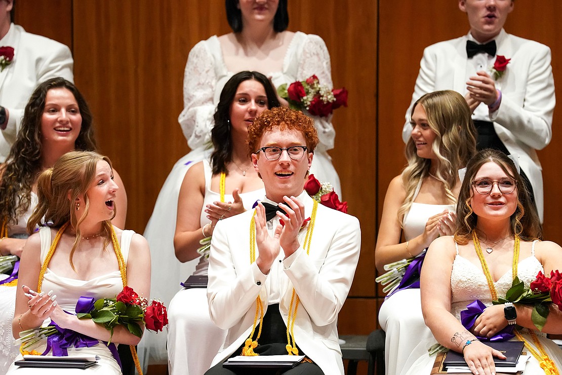 Colin LeFave, center, joins fellow graduates as they applaud the speakers during commencement exercises for Catholic Central School on June 8, at the Massry Center for the Arts in Albany.(Cindy Schultz photo for The Evangelist)