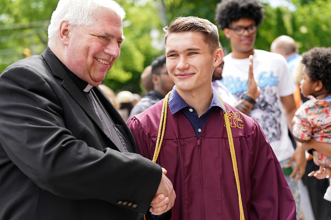 Father Bob Longobucco, left, shakes hands with graduate Tim Kienzle following Notre Dame – Bishop Gibbons commencement exercises on Saturday, June 8, 2024, at St. John the Evangelist Church in Schenectady, N.Y.  Cindy Schultz for The Evangelist