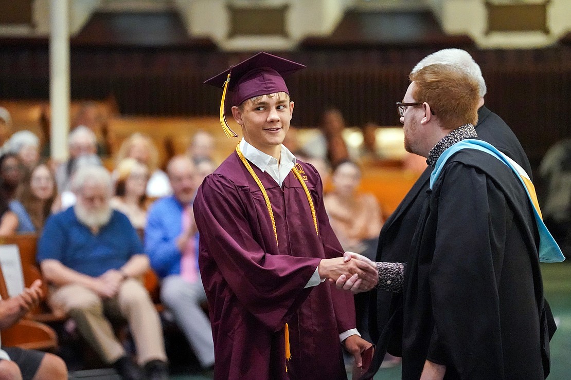 Graduate Cooper McFadden-Wirth, center, receives his diploma during Notre Dame – Bishop Gibbons commencement exercises on Saturday, June 8, 2024, at St. John the Evangelist Church in Schenectady, N.Y.  Cindy Schultz for The Evangelist