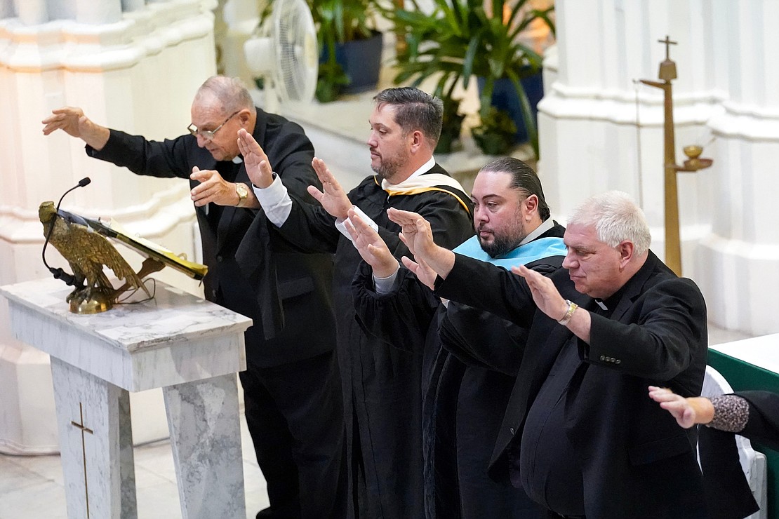 School Chaplain Father Leo Markert, left, leads a blessing of the graduates during Notre Dame – Bishop Gibbons commencement exercises on Saturday, June 8, 2024, at St. John the Evangelist Church in Schenectady, N.Y. Joining him, from left, are principal Patrick Moran, superintendent Giovanni Virgilio Jr. and Father Bob Longobucco.  Cindy Schultz for The Evangelist