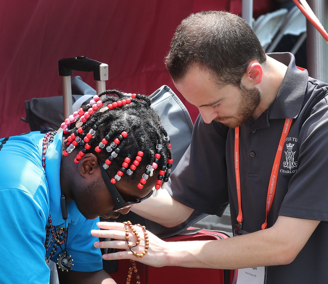 Phillip Pierangeli of West Grove, Pa., prays with a man before the start of the final Eucharistic procession of the National Eucharistic Congress in downtown Indianapolis July 20, 2024. (OSV News photo/Bob Roller)