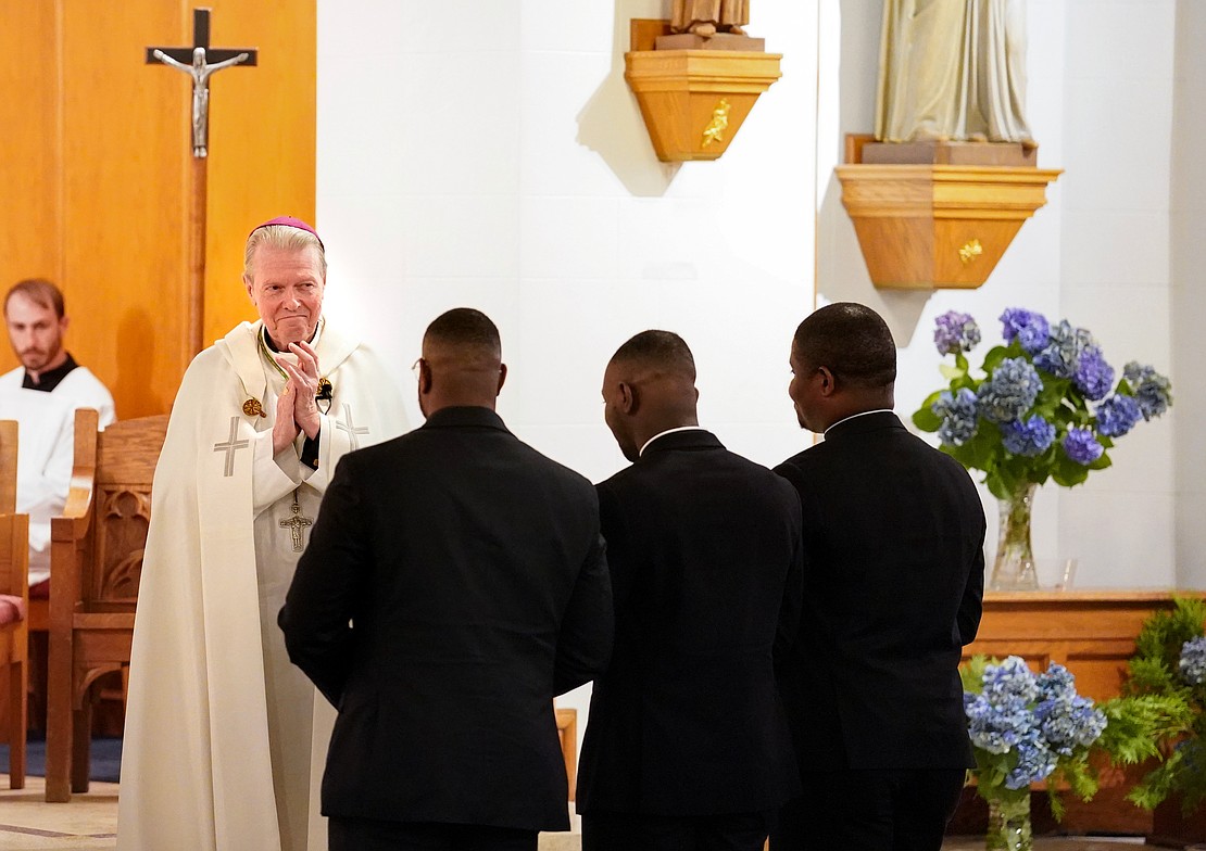 Bishop Edward B. Scharfenberger applauds candidates Franklin Anyanechi (from l.) Zephyrinus Ogbenna and Samuel Zuze during their Rite of Candidacy on Aug. 1 at Holy Trinity Church in Cohoes. (Cindy Schultz photo for The Evangelist)