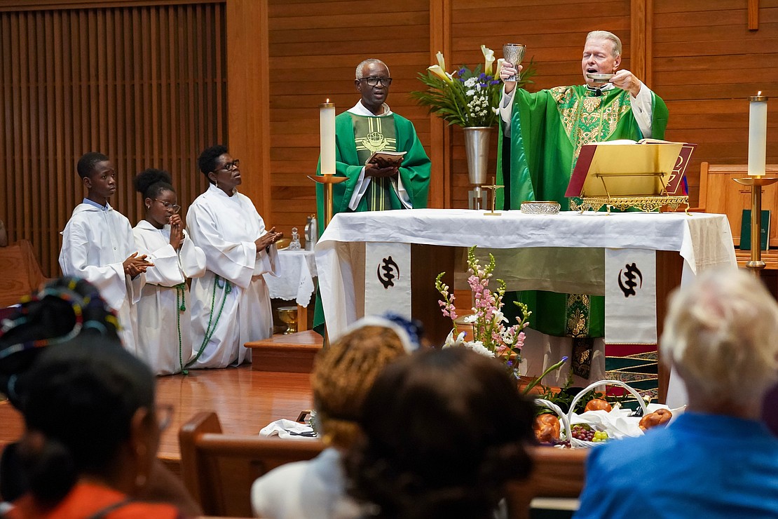 Bishop Edward B. Scharfenberger, right, raises the body and blood of Christ during mass to celebrate the 40th anniversary of the Black Catholic Apostolate on Sunday, Aug.11, 2024, at St. Joan of Arc in Menands, N.Y.  Cindy Schultz for The Evangelist