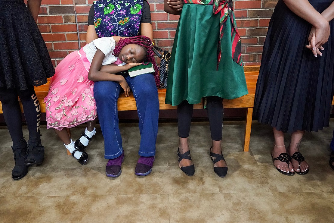 Sybil Chukwudi, 7, uses a Bible for a pillow as she naps during mass to celebrate the 40th anniversary of the Black Catholic Apostolate on Sunday, Aug.11, 2024, at St. Joan of Arc in Menands, N.Y.  Cindy Schultz for The Evangelist